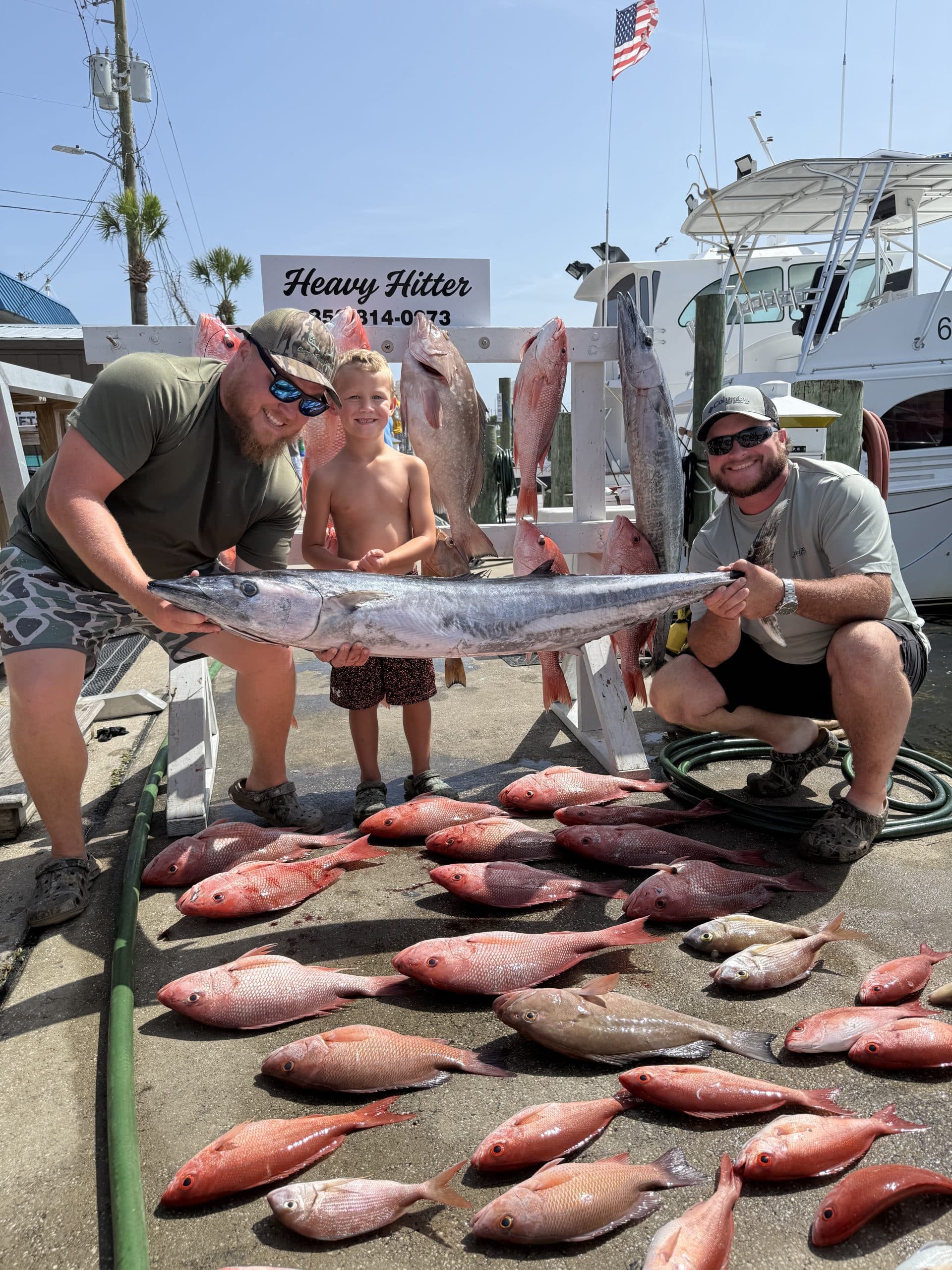 two men and a young boy posing with fishing hual from a trip with Heavy Hitter Charters deep sea fishing in Panama City